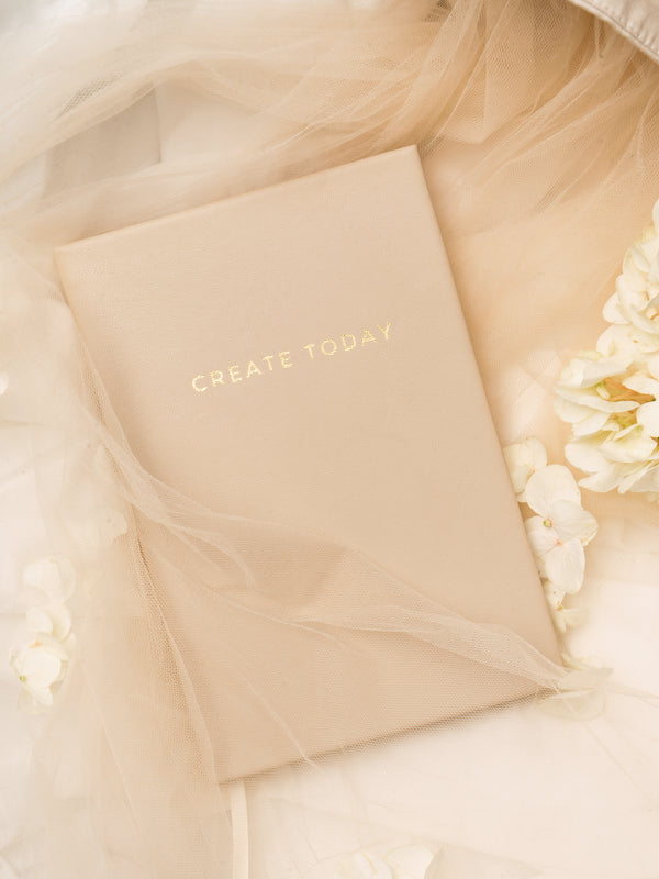 Lavendaire Daily Planner on beige tulle next to flowers